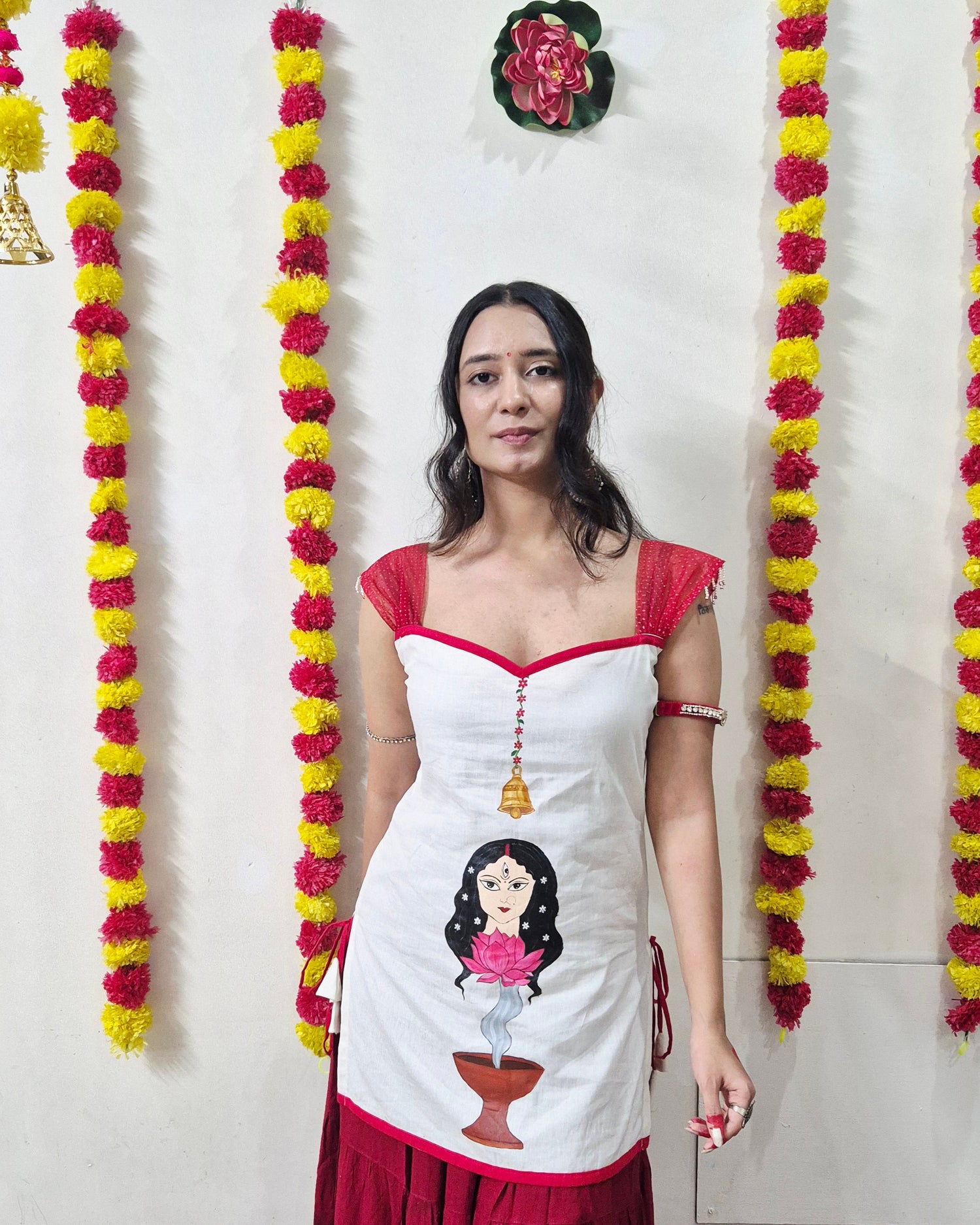 Woman in a red and white dress with floral decorations on a light background
