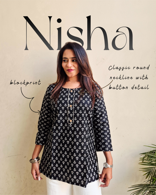 Woman wearing a black floral patterned top with 'Nisha' branding on a beige background