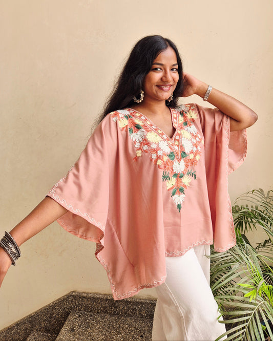 Woman wearing a pink floral dress with a neutral background