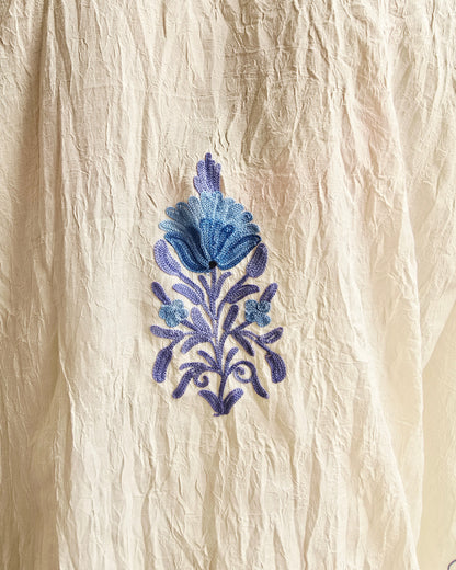 Blue floral embroidery on beige fabric