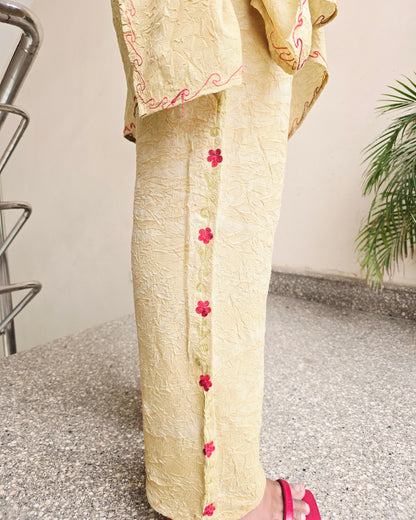 Roll of fabric with pink floral patterns on a textured surface