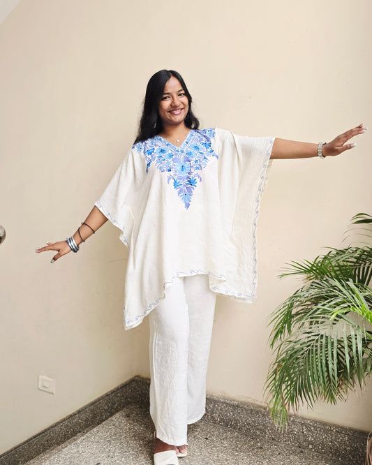 Person wearing a white outfit with floral patterns indoors