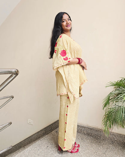 Person wearing a yellow traditional outfit with red patterns on a light-colored floor.