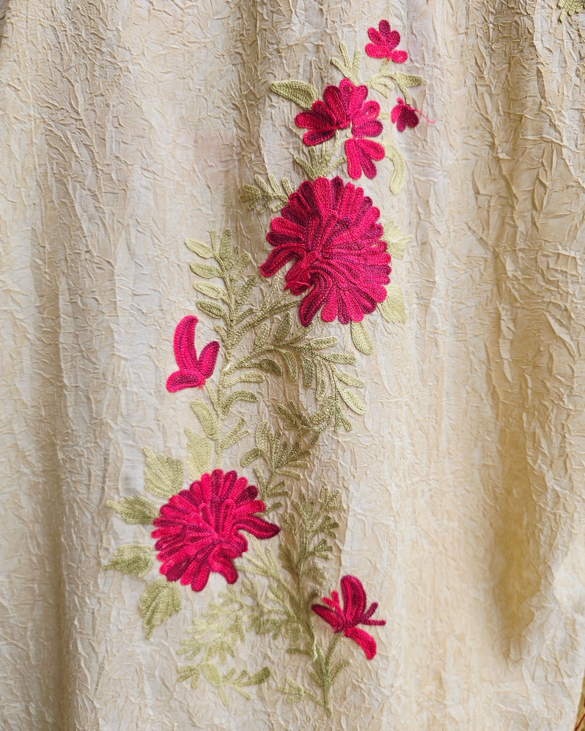 Embroidered fabric with pink flowers on a beige background
