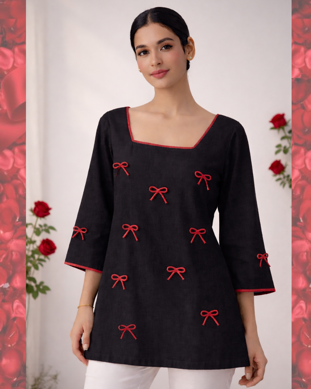 Woman wearing a black top with red bow patterns against a floral background