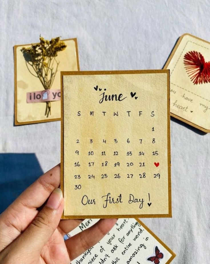Calendar card for June with decorative elements held by a hand on a light background.